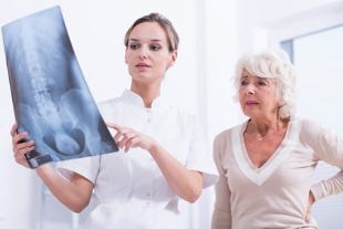 doktor gösterir hastaya röntgen omurga